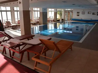 a large swimming pool with chairs and tables in a building at Pavic SPA Milmari L34 in Kopaonik