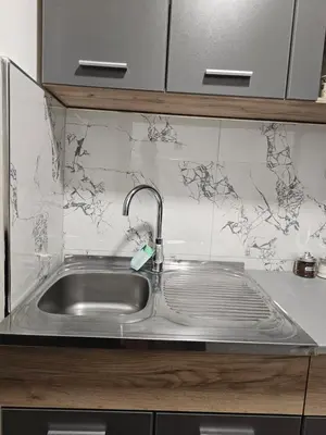 a stainless steel sink in a kitchen with marble tiles at Ema HILLS in Vranje