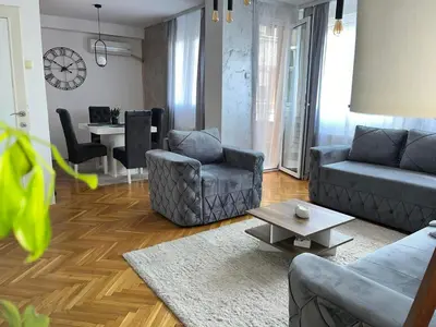 a living room with two couches and a table at Apartment Aleksandrija in Niš