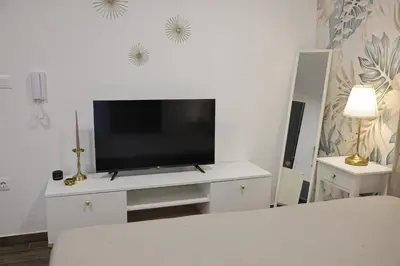 a living room with a tv on a white entertainment center at Adagio Apartmani in Vrnjačka Banja