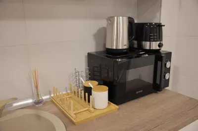 a kitchen counter with a coffee maker on top of a microwave at Adagio Apartmani in Vrnjačka Banja