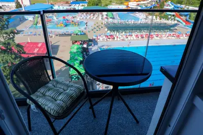 a balcony with a table and chairs and a view of a pool at Vamos a la playa in Jagodina