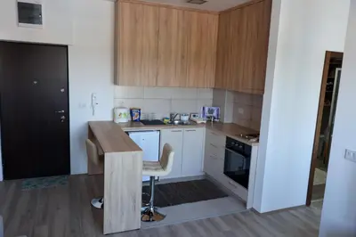 a small kitchen with wooden cabinets and a table at Vamos a la playa in Jagodina
