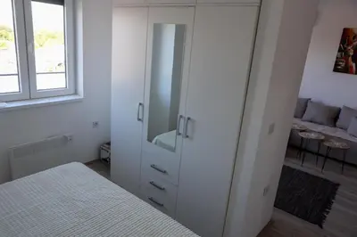 a bedroom with a white cabinet and a bed at Vamos a la playa in Jagodina