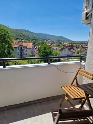 a balcony with a wooden chair and a view at Apartman Nisić in Soko Banja
