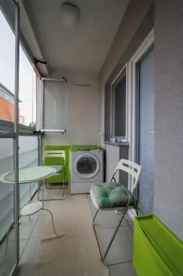a laundry room with a washing machine and a table and chairs at Lux 010 in Pirot