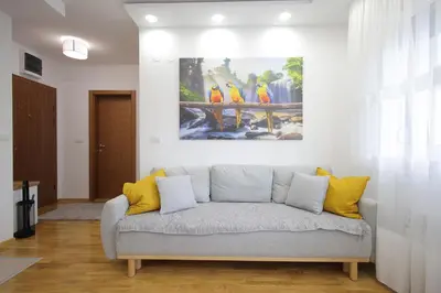 a living room with a couch with a painting on the wall at Vrnjačka oaza in Vrnjačka Banja