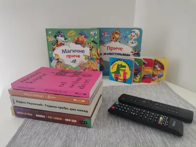 a stack of books next to a remote control at Vrnjačka oaza in Vrnjačka Banja