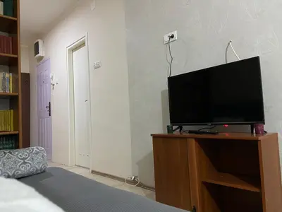 a living room with a flat screen tv on a wooden stand at Apartman Lea in Paraćin
