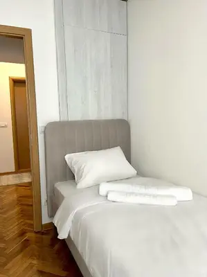 a white bed with two pillows on top of it at Lumo in Niš