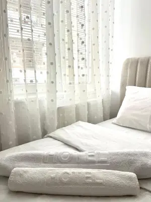 a bedroom with a white bed with a window at Lumo in Niš