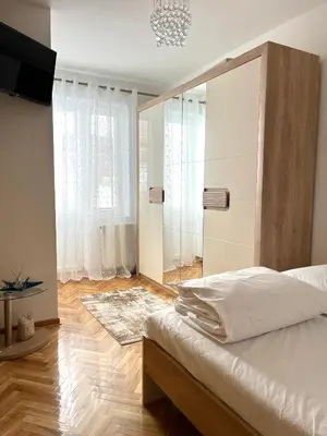 a bedroom with a bed and a large window at Lumo in Niš