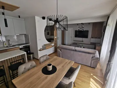 a living room with a table and a couch at Centar Park Lux in Vrnjačka Banja