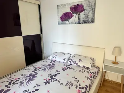 a bedroom with a bed with a floral bedspread at Pahira Lux in Paraćin