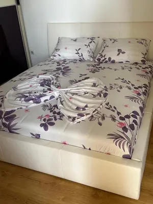 a bed with a floral comforter on top of it at Pahira Lux in Paraćin