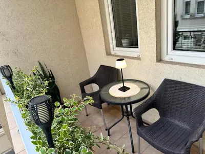 a patio with two chairs and a table and some plants at Pahira Lux in Paraćin