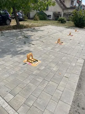 a concrete parking lot with orange barriers on it at HelVik Apartman Aqua Park in Vrnjačka Banja