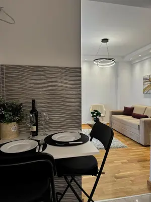 a living room with a table and chairs and a couch at HelVik Apartman Aqua Park in Vrnjačka Banja