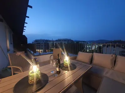 a wooden table with two candles on a balcony at HelVik Apartman Aqua Park in Vrnjačka Banja