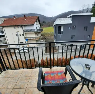 a balcony with a table and chairs and buildings at Studio Djukić Sokobanja in Soko Banja