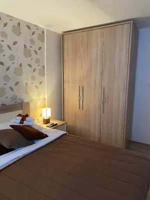 a bedroom with a large bed with a wooden cabinet at Villa Snow Queen Kopaonik in Kopaonik