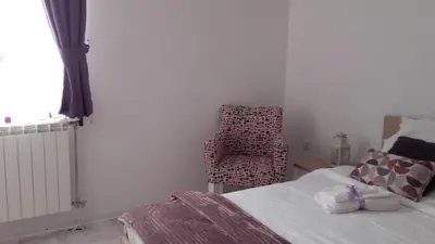 a bedroom with a bed and a chair in it at Villa Snow Queen Kopaonik in Kopaonik