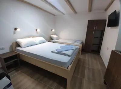 a bedroom with two beds and a tv in it at Porta Simića in Ribarska Banja