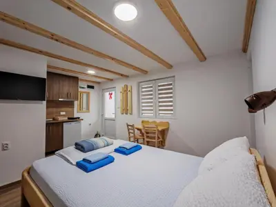 a bedroom with a large bed with blue pillows on it at Porta Simića in Ribarska Banja