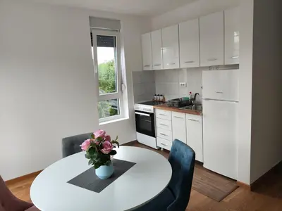 a kitchen with a table with a vase of flowers on it at Apartman Popovic in Soko Banja
