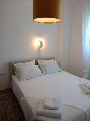 a white bed with a white towel on it at Jagodina Apartman Nastasija- gleda na Aqva park in Jagodina
