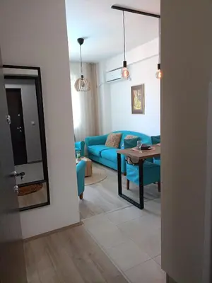 a living room with a blue couch and a table at Jagodina Apartman Nastasija- gleda na Aqva park in Jagodina