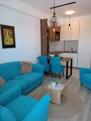 a living room with blue couches and a table at Jagodina Apartman Nastasija- gleda na Aqva park in Jagodina