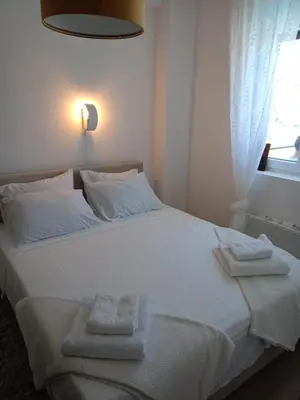 a bedroom with a white bed with towels on it at Jagodina Apartman Nastasija- gleda na Aqva park in Jagodina
