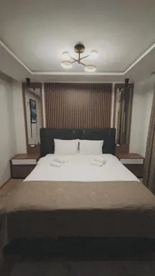 a bedroom with a large bed with two towels on it at Vila Golija Peak Suites in Kopaonik