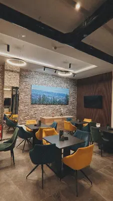 a restaurant with tables and chairs and a brick wall at Vila Golija Peak Suites in Kopaonik