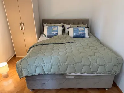 a bedroom with a large bed with blue pillows at Petra Apartments in Jagodina