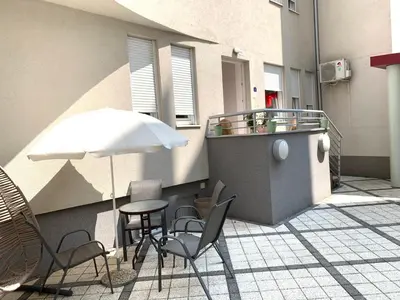 a patio with a table and chairs and an umbrella at Petra Apartments in Jagodina