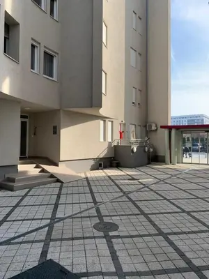 an empty courtyard of a building with two tall buildings at Petra Apartments in Jagodina