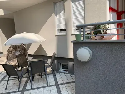 a patio with a table and chairs and an umbrella at Petra Apartments in Jagodina