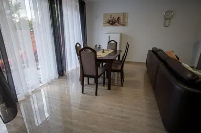 a dining room with a table and chairs and a couch at Raj Petrović in Kovanluk