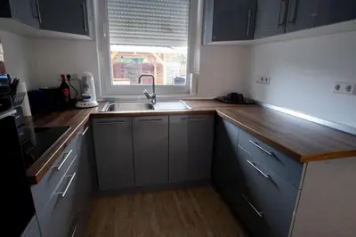a kitchen with white cabinets and a sink and a window at Raj Petrović in Kovanluk