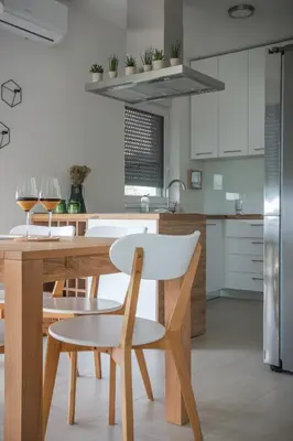 a kitchen with a wooden table and a white chair at Hacienda R - kuca sa bazenom in Siokovac