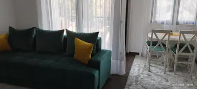 a living room with a green couch and a table at CENTAR CEPERKOVIC in Vrnjačka Banja