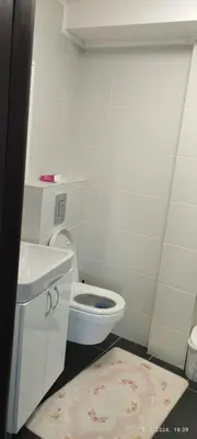 a white bathroom with a toilet and a sink at CENTAR CEPERKOVIC in Vrnjačka Banja