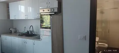 a kitchen with white cabinets and a stove top oven at CENTAR CEPERKOVIC in Vrnjačka Banja