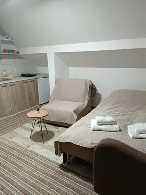 a bedroom with two beds and a small table at Apartman SJAJ in Soko Banja