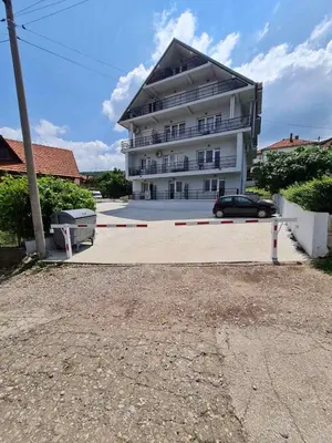 a large building with a car parked in front of it at Apartman SJAJ in Soko Banja