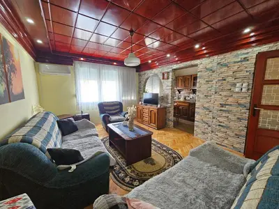 a living room with two couches and a stone wall at Apartman Purić in Pirot