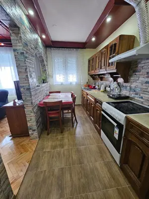 a kitchen with a table and a stove top oven at Apartman Purić in Pirot