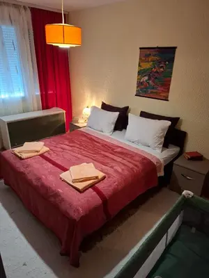 a bedroom with a red bed with two towels on it at Apartman Purić in Pirot